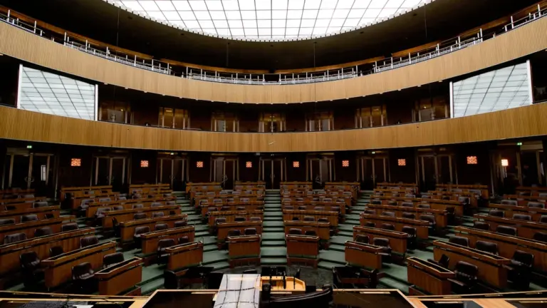 Tuščia posėdžių salė, kurioje vyksta svarbūs valstybiniai sprendimai ir diskusijos dėl biudžeto.