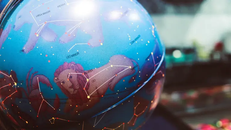Šviečiantis gaublys su pavaizduotais zodiako ženklais ir žvaigždynų žemėlapiu tamsiame fone