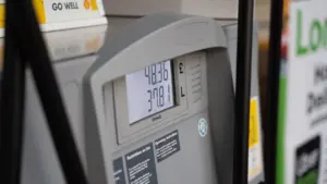 Degalinės kuro pylimo kolonėlė su skaitmeniniu ekranu rodančiu kuro kainas.