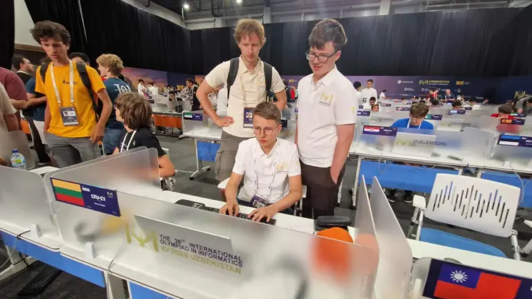 Jaunuoliai su Lietuvos komandos apranga dirba prie kompiuterių tarptautinėje informatikos olimpiadoje Uzbekistane.