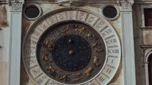 Istorinis astronominis laikrodis ant pastato sienos su aiškiai matomais Zodiako ženklais